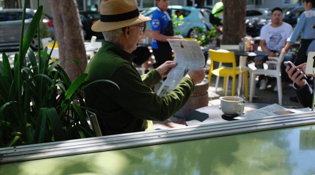 Disfrutando de la sombra en la terraza de un bar leyendo el periódico